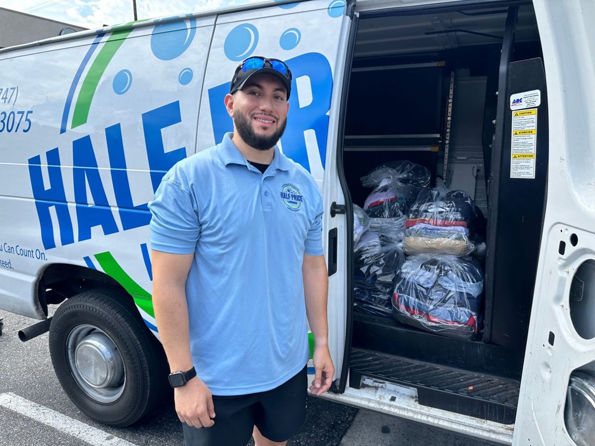 Half Price Laundry driver beside the pickup and delivery van loaded with customer laundry