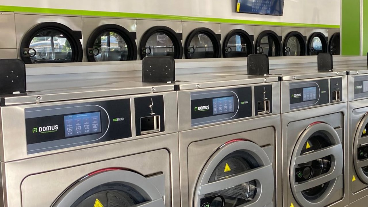 Commercial-grade stainless front-load washers at a Half Price Laundry store