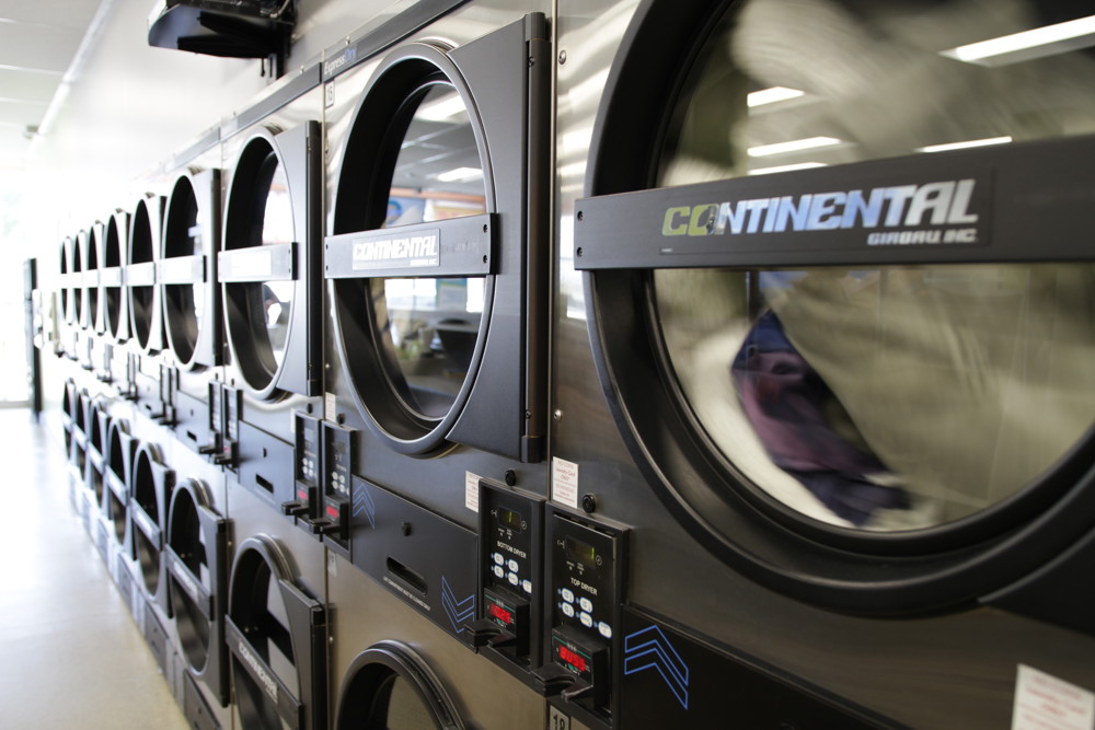 Row of large-capacity front-load washers at Half Price Laundromat