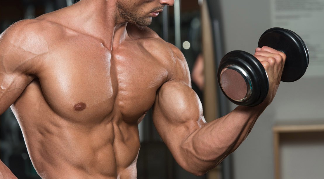 Muscular Bodybuilder Doing Biceps Workout With A Bicep Curl