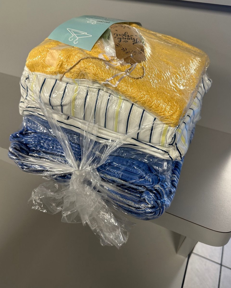 A finished wash and fold order: towels and sheets folded, bagged and tagged with a thank-you note