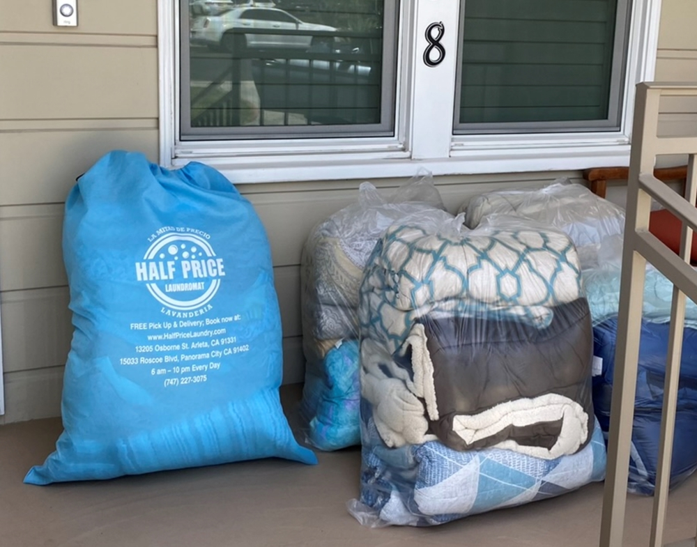 Branded Half Price Laundry bags of clean laundry delivered to a customer's doorstep
